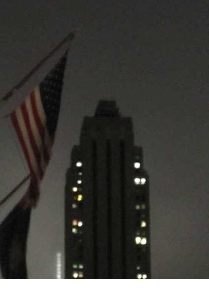 Evening image of New York skyscraper and American flag